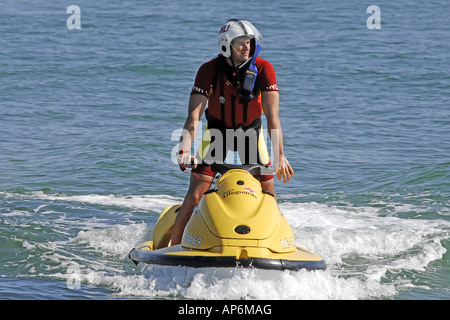 RNLI Strand Wasser Streifenpolizist auf einem Jetski Wache für Schwimmer in Not Stockfoto