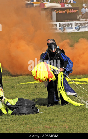 Fallschirmspringer sammeln Sie ihre Fallschirme cafefully nach der Landung auf einem öffentlichen Arena event Stockfoto