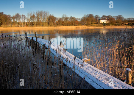 Schneebedeckter Holzsteg am See Rådasjön, Schweden Stockfoto