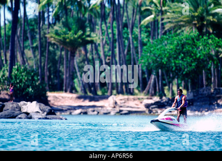 Jet Ski vor Palmen gesäumt blaue Meer Wellen Strandsand tropischen Stockfoto