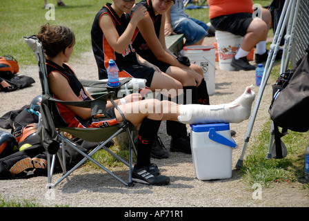 Weibliche Softball Spieler Verstauchungen Sprunggelenk von Sportverletzungen durch Baseball spielen Stockfoto