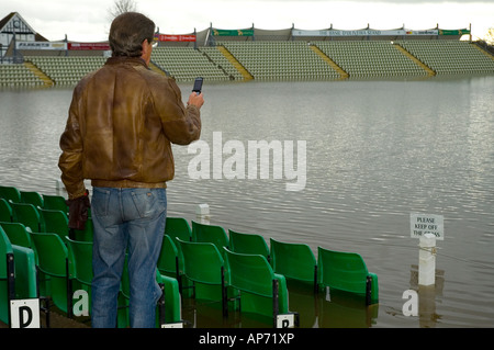 Mann nimmt Foto überflutet Cricket ground auf Handy, Worcester, England Stockfoto