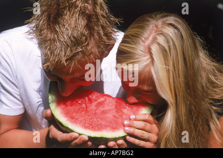 Junges Paar derselben Scheibe Wassermelone essen Stockfoto