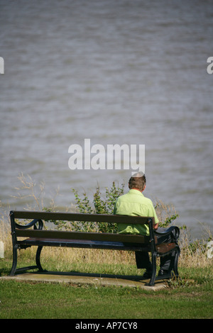 Einsamer Mann sitzt auf einer Bank am Meer, Frinton-on-Sea, Essex, England, UK. Stockfoto