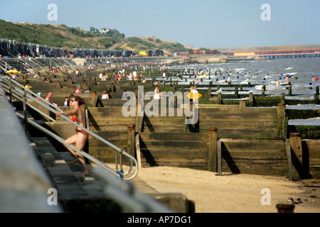 Buhnen und Besucher am Strand von Frinton-on-Sea, Essex, England, UK. Stockfoto