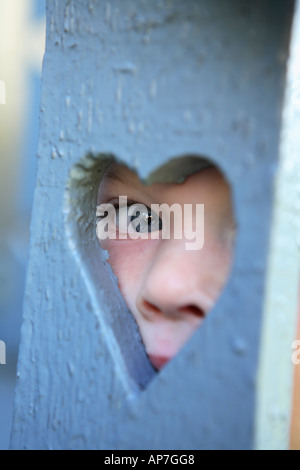 Zwei Jahre alter Junge herzförmige Loch mit Blick Stockfoto