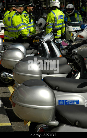 London metropolitan Polizeioffiziere tragen hell gelb reflektierende Jacken hinter dem geparkten Polizei Motorroller Stockfoto