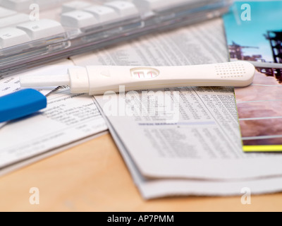 Schwangerschaftstest auf Schreibtisch Stockfoto
