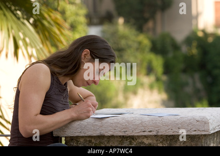 Junge Frau schreiben Postkarten auf Marmorsäule in Asolo, Italien Stockfoto