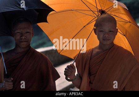 Mönche mit Sonnenschirmen Abschirmung von der tropischen Sonne in der Nähe von Wat Xieng Thong Luang Prabang Laos Stockfoto