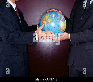 Mitte Schnittansicht von zwei Geschäftsleute halten Globus Stockfoto