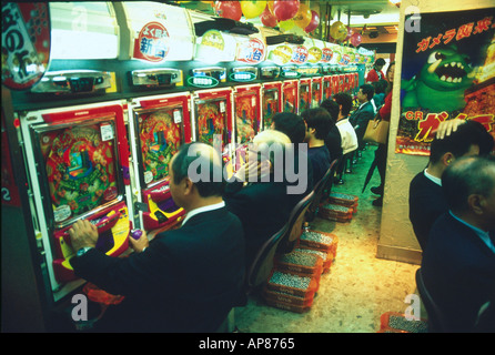 Seitenprofil Gruppe von Männern auf Pachinko Maschinen in Tokyo Japan Casino spielen Stockfoto