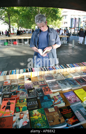 Mann ein Buch unter den Bögen der Waterloo Bridge London durchsuchen Stockfoto