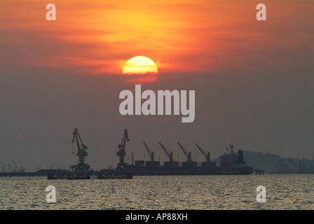 Silhouette der Frachter im Hafen bei Sonnenuntergang Stockfoto