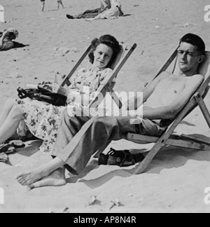 ALTE SCHWARZ / WEIß FAMILIE FOTOGRAFIE SNAP SHOT DES PAARES IM DECK SITZEN STÜHLE AM STRAND UM 1950 Stockfoto