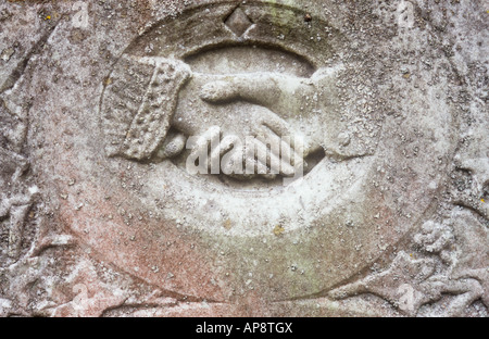 Detail der Stein Grabstein in die wurde eine männliche Hand auszustrecken und halten oder eine weibliche Hand schütteln geschnitzt Stockfoto