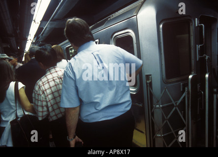 Menschenmenge, die an der U-Bahn-Haltestelle des Bahnsteigs Grand Central Station in den U-Bahn-Zug steigen. Täglich an Wochentagen pendeln Sie in Midtown Manhattan, New York City Stockfoto