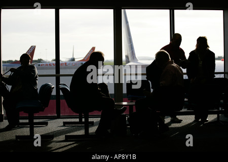 Passagier wartet in Lounge vor Fenster in Nordirland Belfast International airport Stockfoto