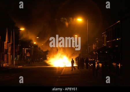 Mann geht vor brennenden Bus auf Cambrai Straße Belfast während Loyalist Unruhen Belfast Nordirland Stockfoto