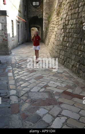 Junge Touristen zu Fuß auf den Marmor Pflastersteinen vom Südtor von der mittelalterlichen Stadt von Kotor, Montenegro Stockfoto