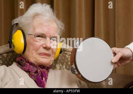 Ältere Dame tragen Ohr ^ Verteidiger und selbstgefälligen Blick Stockfoto