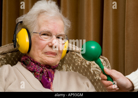 Ältere Dame tragen Ohr ^ Verteidiger und selbstgefälligen Blick Stockfoto