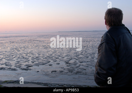 Eine Person, die mit Blick auf die flache Watt der Nationalpark Niedersächsisches Wattenmeer Deutschland Stockfoto