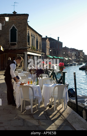 Restaurant am Kanal mit Kellner in Murano, Venedig, Italien Stockfoto