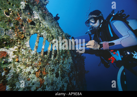 Scuba Diver wirft ein Licht auf die Breitseite des Jabeda Wracks Stockfoto