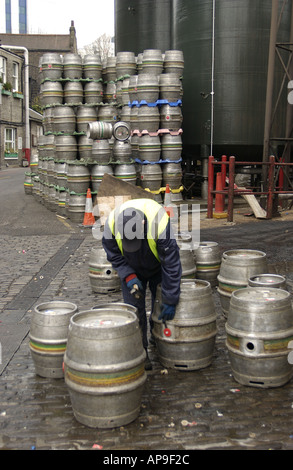 Entfernen von Dichtungen aus leeren Bierfässern zum Nachfüllen der Youngs Brauerei Wandsworth London Mann Stockfoto