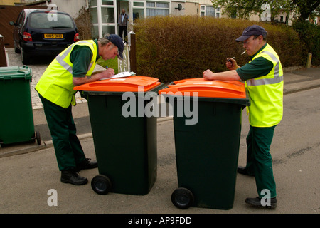 Des Rates Arbeitnehmer liefern orange Top Wheelie Lagerplätze an Bewohner der Stadt für das recycling von Gartenabfällen in Newport City, South Wales, UK Stockfoto