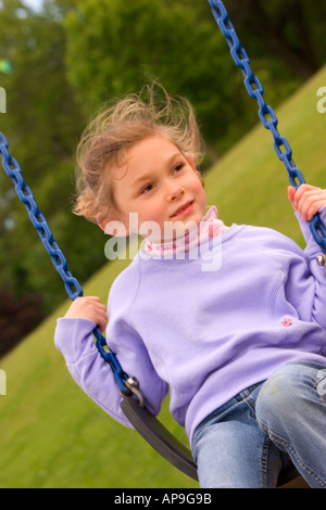 Ein junges Mädchen gerne geschwungen und spielt in einem lokalen park Stockfoto