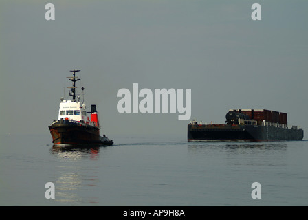 Abschleppen von einem Lastkahn auf flachen Freiwasser Schlepper Stockfoto