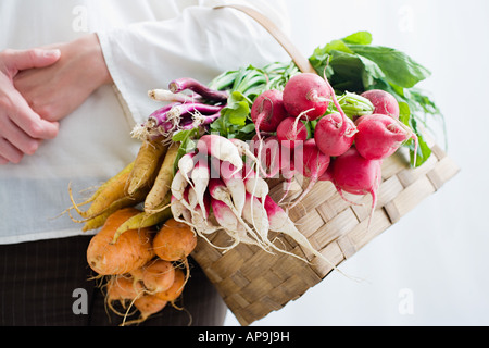 Frau hält Korb mit rote Beete und Radieschen Stockfoto