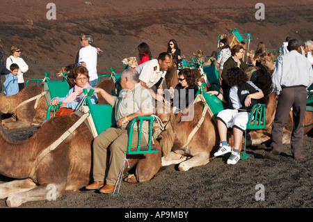 Touristen auf Kamelen im Timanfaya Nationalpark auf Lanzarote. Stockfoto