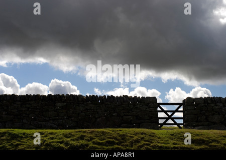 Silhouette von Trockenmauern Wand Tor an einem bewölkten stürmischen englischen sonnigen Tag Stockfoto