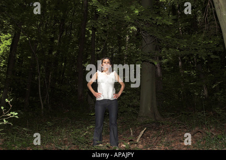Junge Frau allein im Wald wegschauen Stockfoto