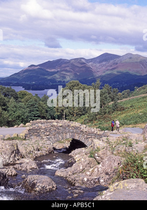 Historische, sonnige Ashness Packhorse Bridge Wanderer machen sich auf den Weg zum Derwentwater Skiddaw Berg Keswick, alles im Shadow Lake District Cumbria England Großbritannien Stockfoto