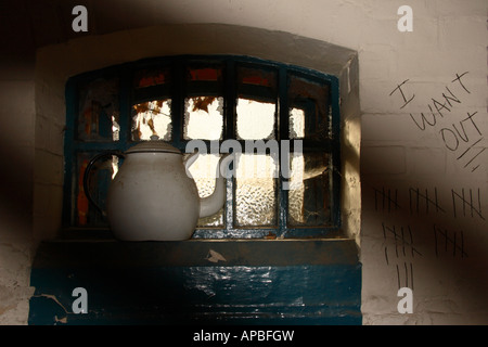 Ein Fenster in einem alten stillgelegten Gefängniszelle. Stockfoto