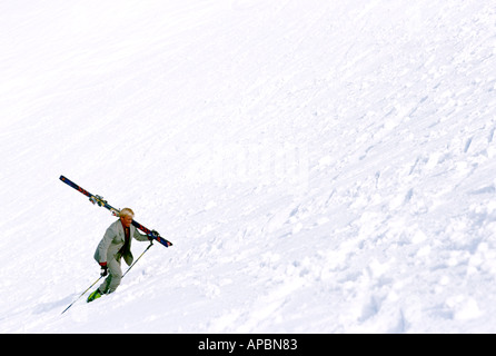 Mann zu Fuß auf steilen Skislope im Business-Anzug Stockfoto