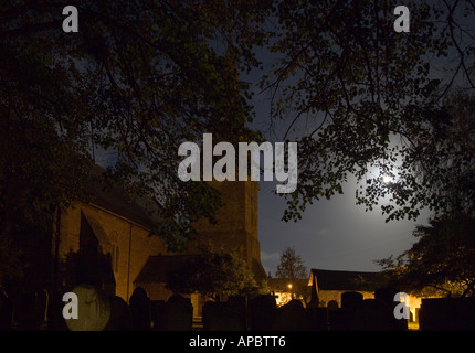 Vollmond durchschimmern lässt Bäume über dem Friedhof Steinen in St Brannock Pfarrei Kirche Braunton Devon England Stockfoto