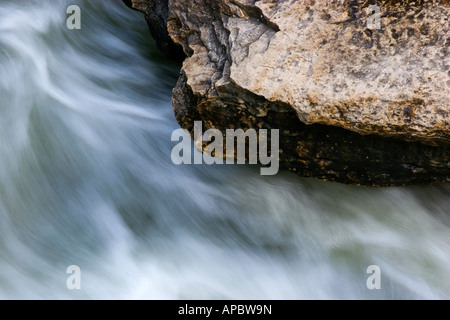 Wasser rauscht vorbei an einem Felsvorsprung unter Wasser fallen am Tanyard Creek Trail in Bella Vista, Arkansas Stockfoto