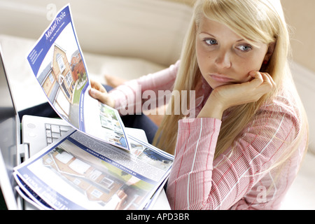 junge Frau betrachten Angaben für Häuser und Wohnungen Stockfoto