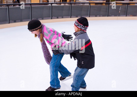 Bruder und Schwester jagten einander während des Skatens in Northstar-Ski-Resort in der Nähe von Truckee, Kalifornien Stockfoto