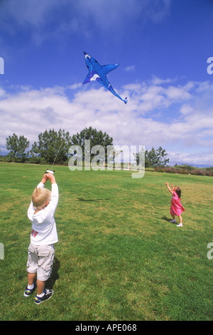 Jungen und Mädchen fliegen Drachen zusammen Stockfoto