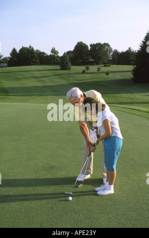 Golfer weist Enkelin auf Golfplatz Stockfoto