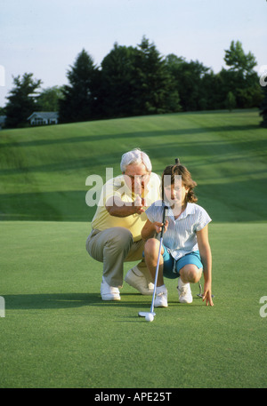 Enkelin nimmt Golfunterricht von Großvater Stockfoto