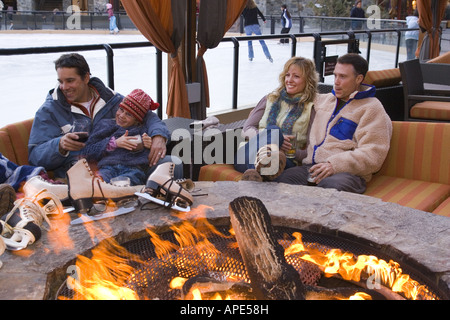 Eine Familie und Freunde sitzen neben einem Feuer auf der Eisbahn in Northstar-Ski-Resort in der Nähe von Lake Tahoe in Kalifornien Stockfoto