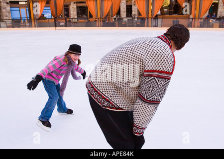 Ein Mädchen jagen ihr Vater während des Skatens in Northstar-Ski-Resort in der Nähe von Truckee, Kalifornien Stockfoto