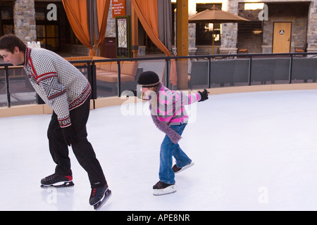 Ein Mädchen jagen ihr Vater während des Skatens in Northstar-Ski-Resort in der Nähe von Truckee, Kalifornien Stockfoto